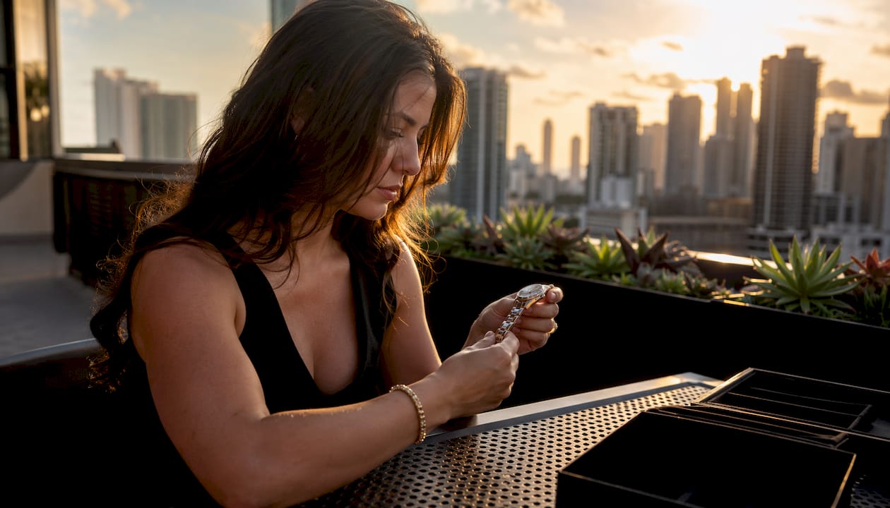 Woman examining luxury 30mm watch in home office