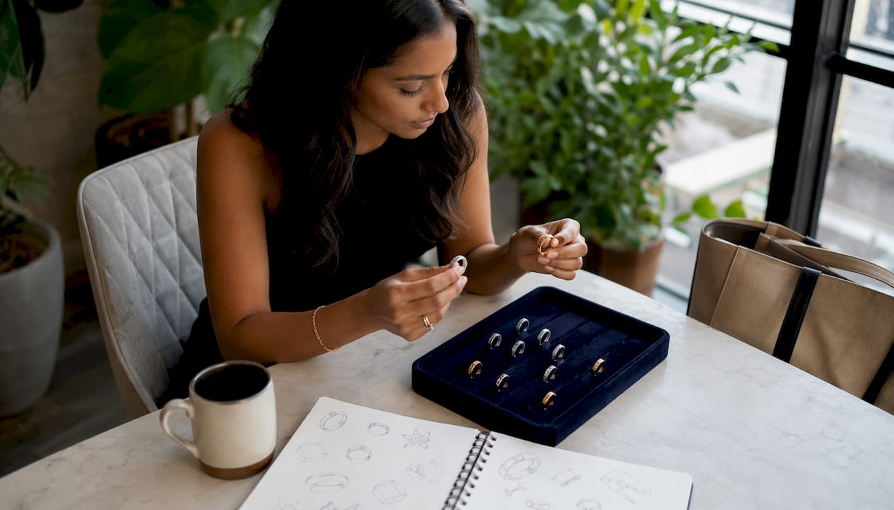 Woman comparing Cartier Love ring alternatives at desk