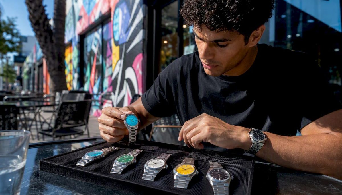 Man examining colorful automatic wristwatches indoors