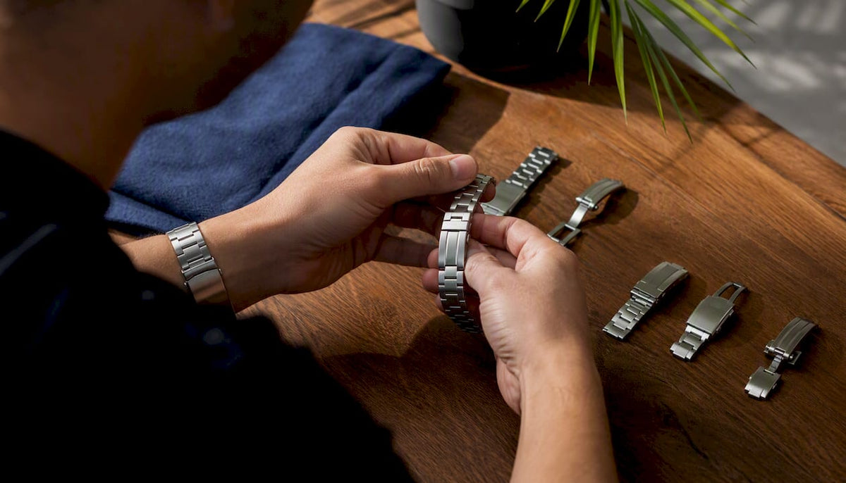 Hands securing different bracelet clasps