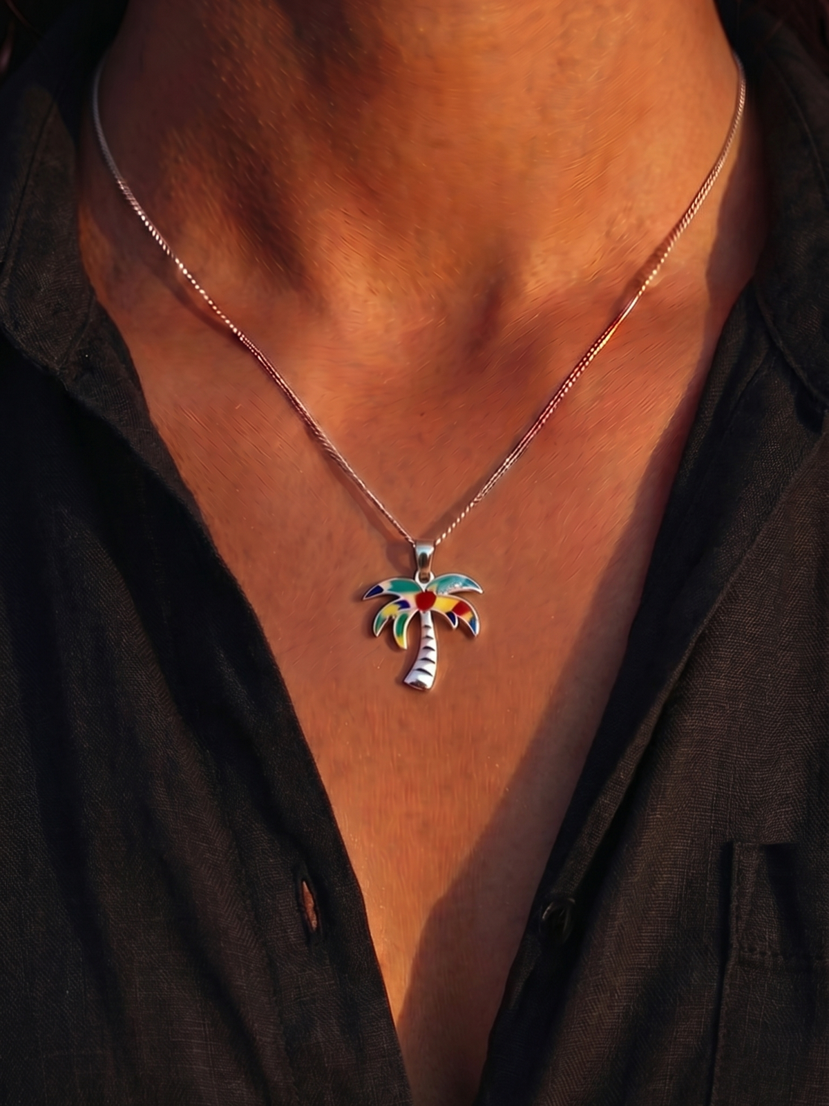 Close-up of a woman wearing the WYNWOOD BLVD Painted Silver Palm Tree Charm necklace inspired by Miami during golden hour.