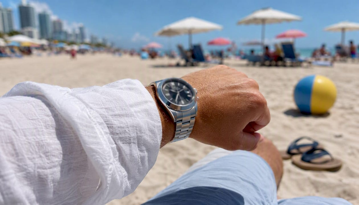 Partial wrist with stainless steel watch and Miami background