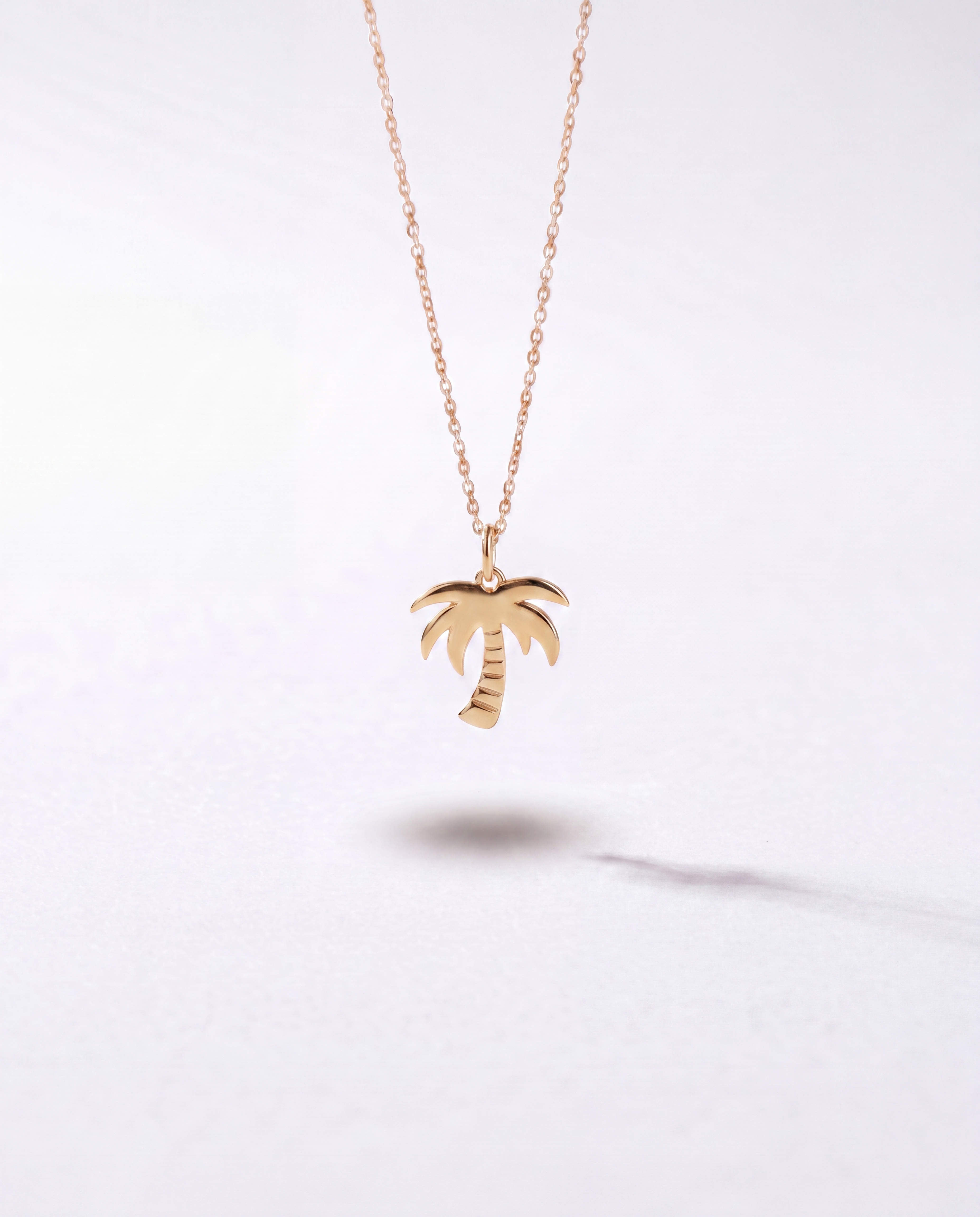 Silver palm tree pendant necklace by WYNWOOD BLVD on a clean white background.