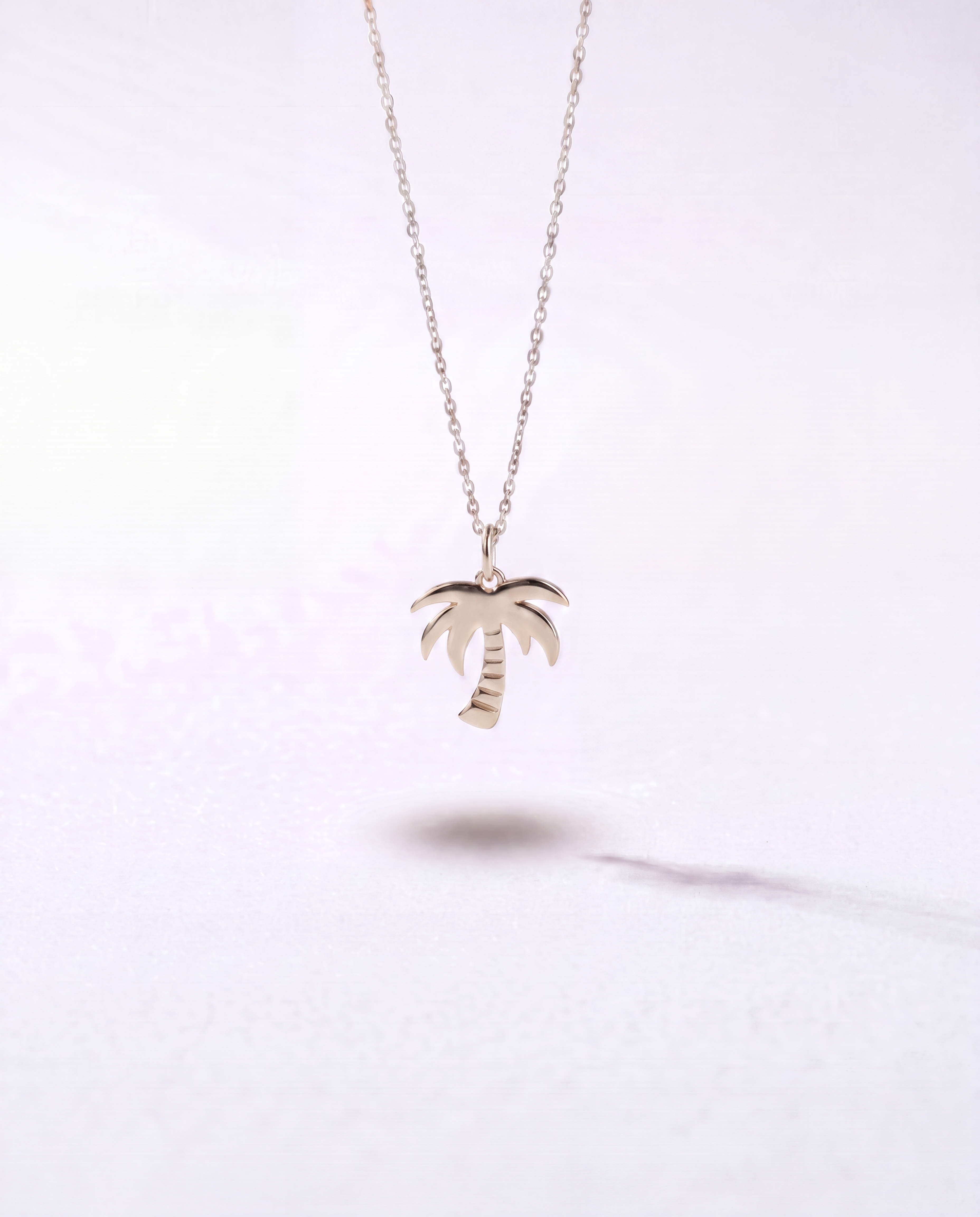 Silver palm tree pendant necklace by WYNWOOD BLVD on a clean white background.