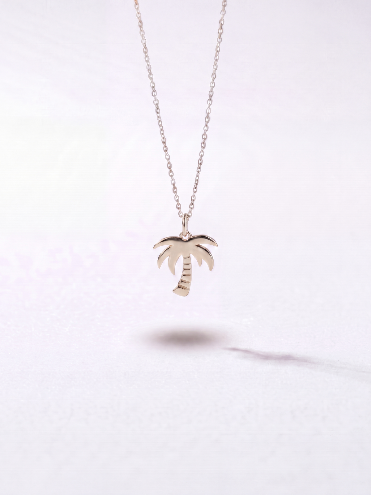 Silver palm tree pendant necklace by WYNWOOD BLVD on a clean white background.